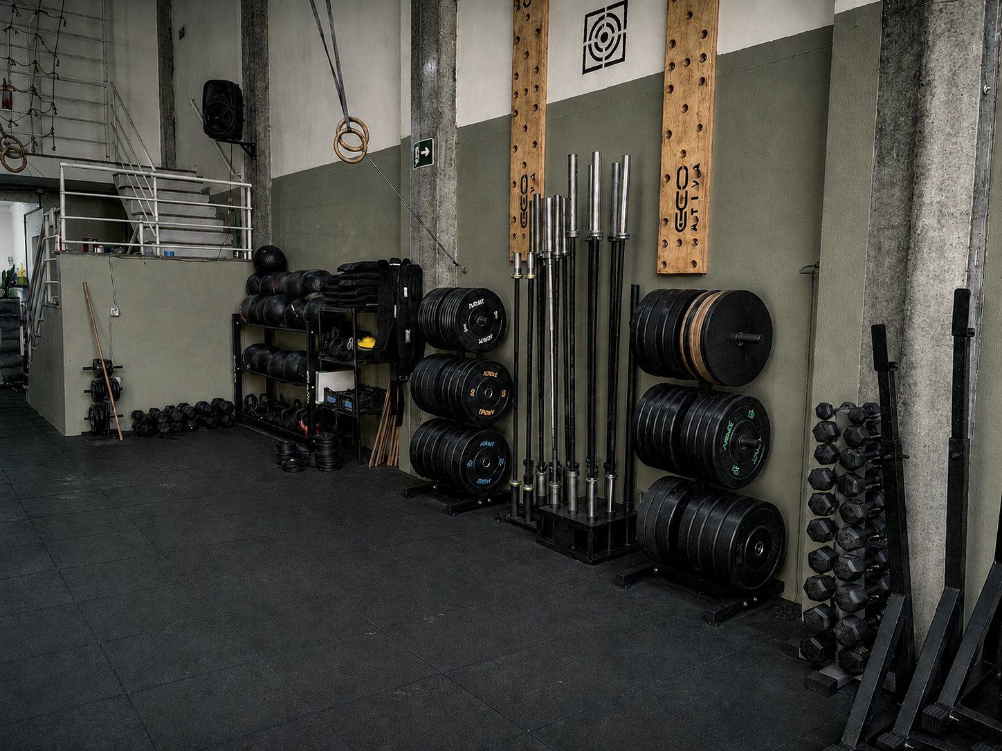 Barras, anilhas, halteres e equipamentos organizados no box